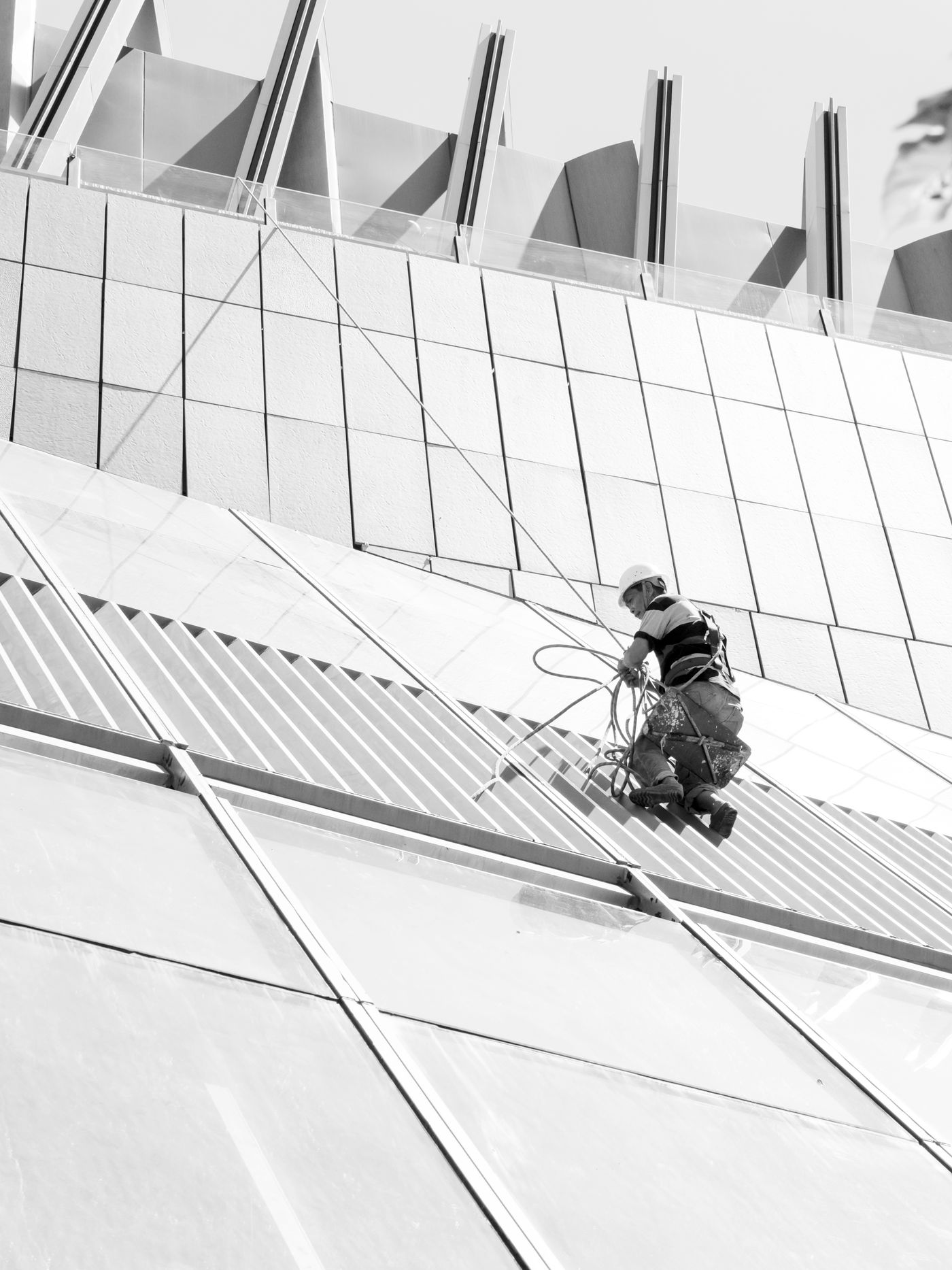Arbeiter mit Seilausrüstung an einer Gebäudefassade; Symbolfoto für Tätigkeiten in der Höhe